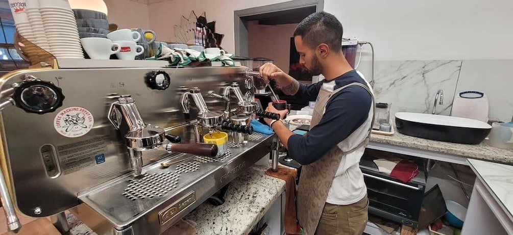 A barista preparing coffee using a professional espresso machine in a kitchen setting. 3