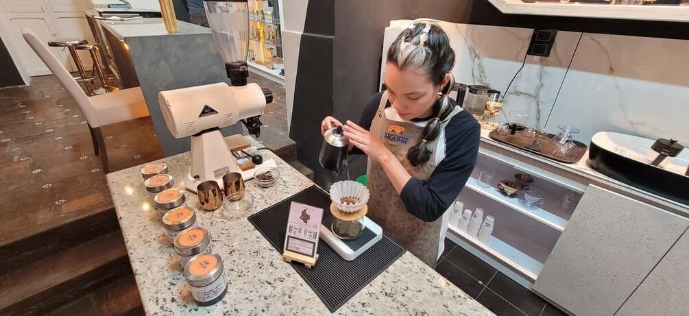 A person preparing food at a counter with various kitchen appliances and ingredients. 5