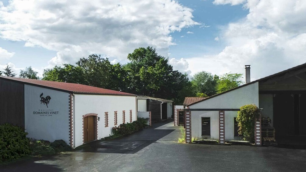 A vineyard estate with white buildings, brick accents, and a clear sky. 3