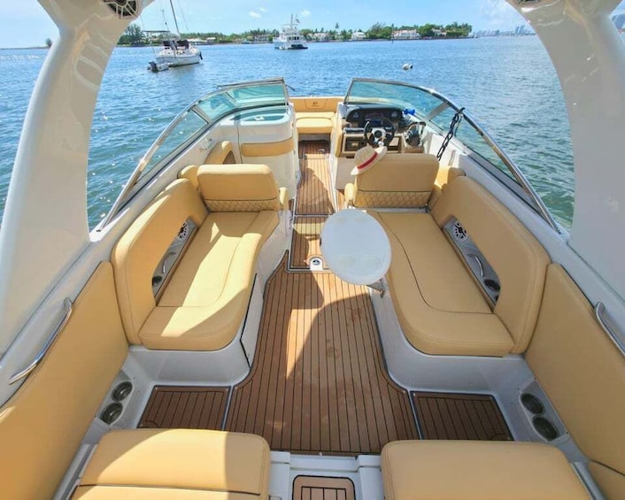 A boat's interior with beige leather seating and a central table. 1