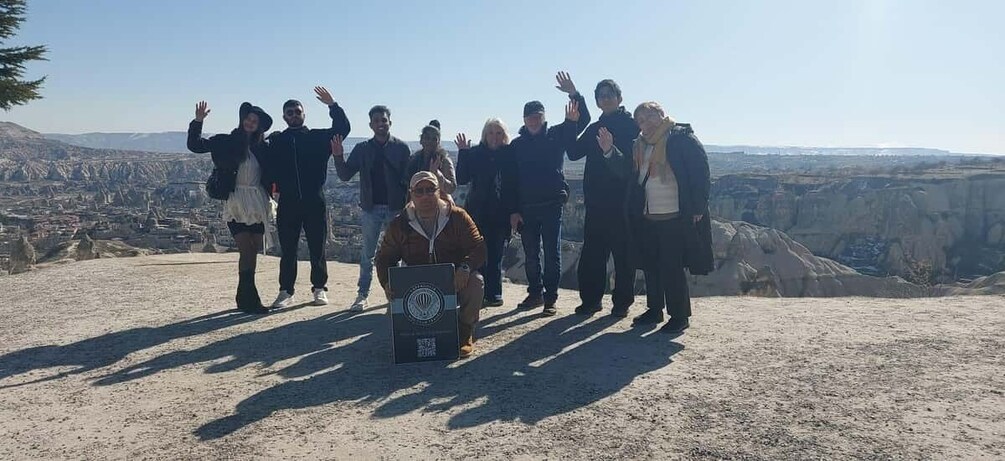 A group of people standing on a hill with a cityscape in the background. 4