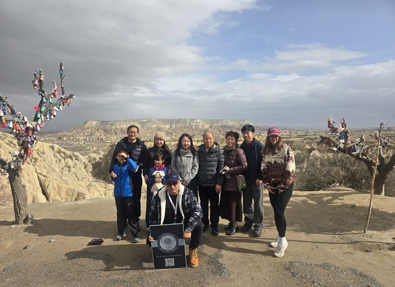 A group of people standing on a rocky outcrop with a mountainous landscape in the background. 5