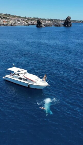 A boat on a calm sea with rocky outcrops in the background. 1