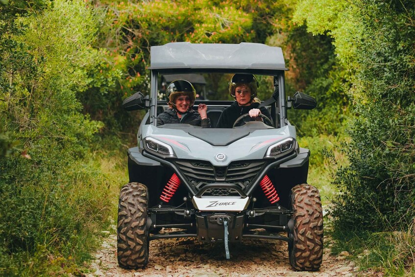A vehicle with 'Force' branding on the front, driving on a dirt path surrounded by greenery. 3