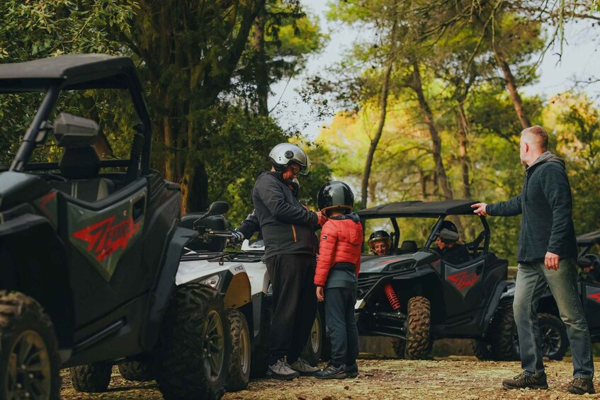 An off-road vehicle with 'Storm' branding, a person in a red jacket, and another person in a black jacket. 5