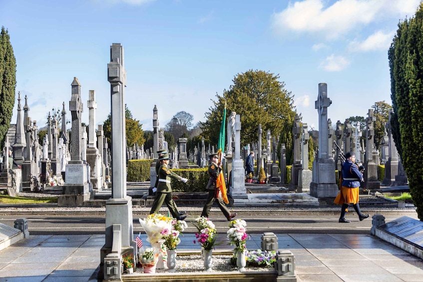 A cemetery with numerous gravestones and memorials, some adorned with flowers. 3