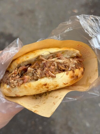 A sandwich in a paper wrapper. 5