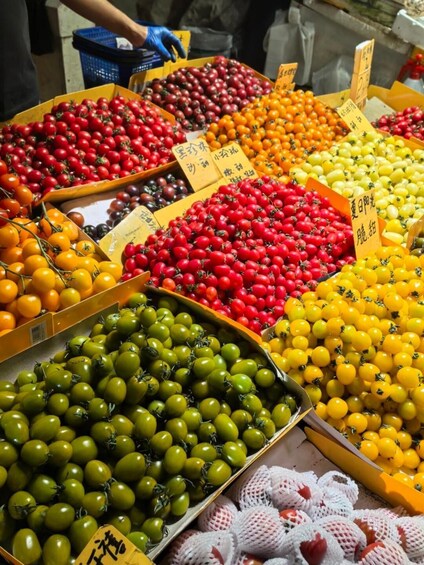 A variety of tomatoes in boxes with price tags. 3