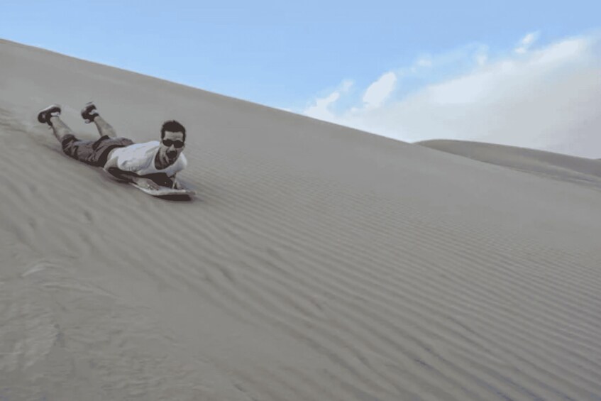 A person lying on a sand dune. 2