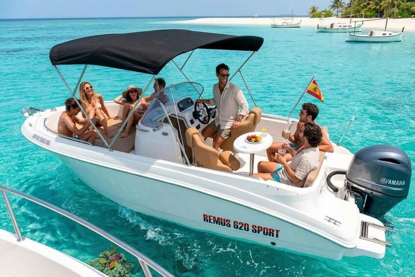 A white boat named 'REMUS 620 SPORT' on turquoise water with a black canopy, surrounded by clear skies and distant islands. 2