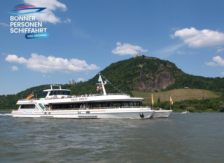 A boat named FILIA RHENI on a body of water with a mountainous landscape in the background. 3