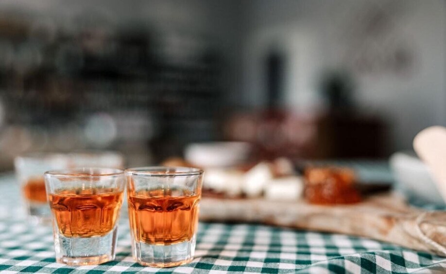 Two glasses of amber liquid on a checkered tablecloth. 3