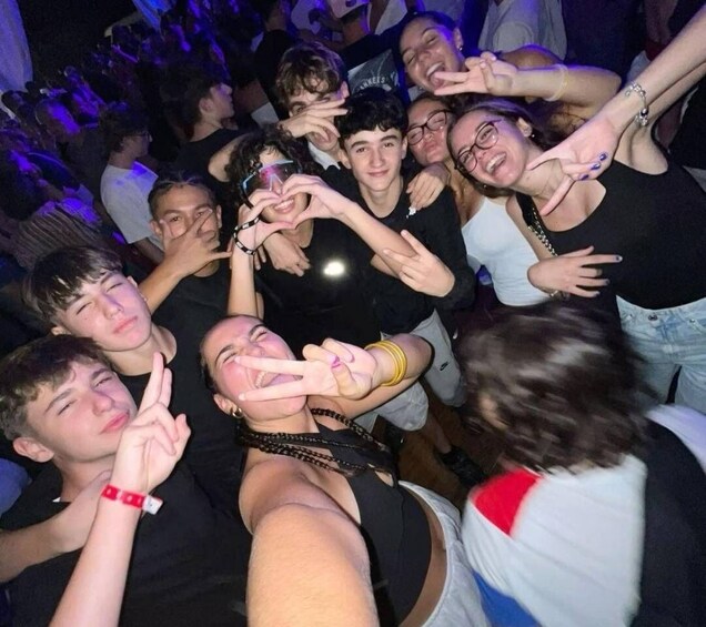 A group of people at a social event, some making hand gestures. 2