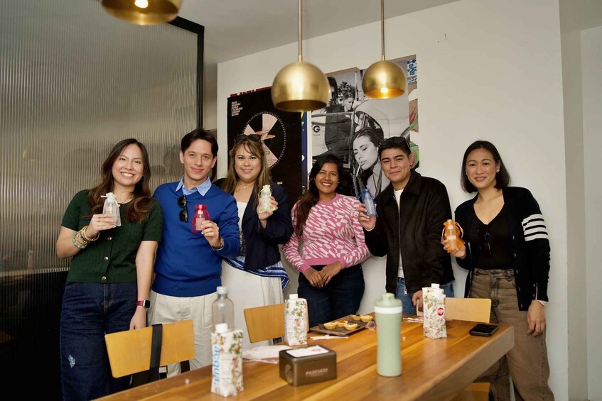 A group of people standing around a table with food and drinks. 1