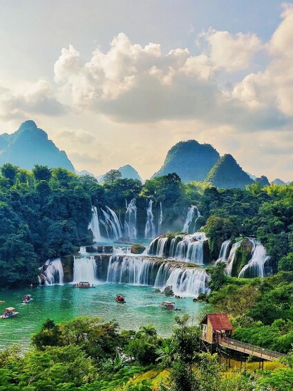 A multi-tiered waterfall surrounded by lush greenery and mountains. 4