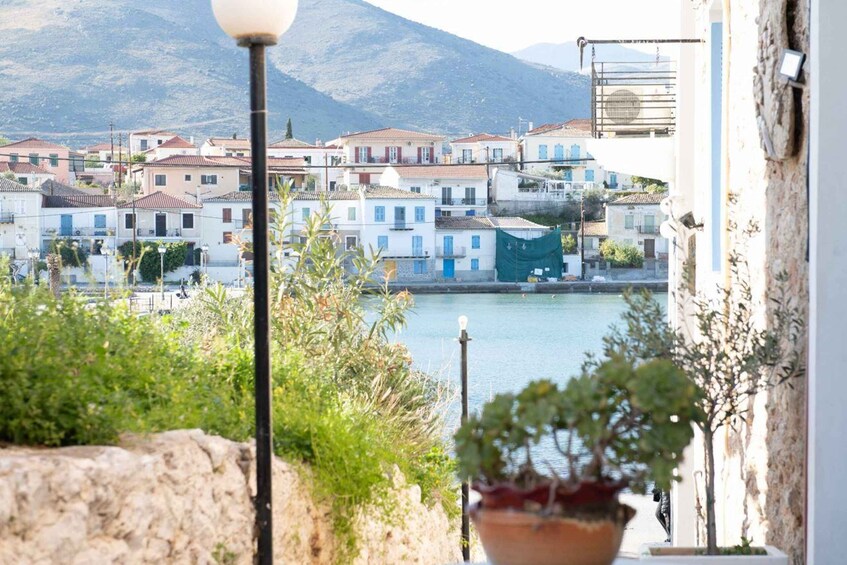A coastal town with buildings, a body of water, and mountains in the background. 3