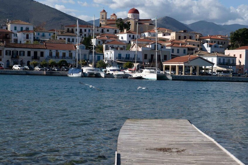 A coastal town with white buildings, a wooden pier, and boats in the water. 2