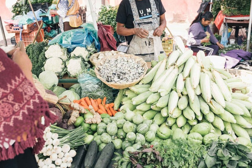 A market stall with various vegetables like cauliflower, carrots, and cucumbers. 5