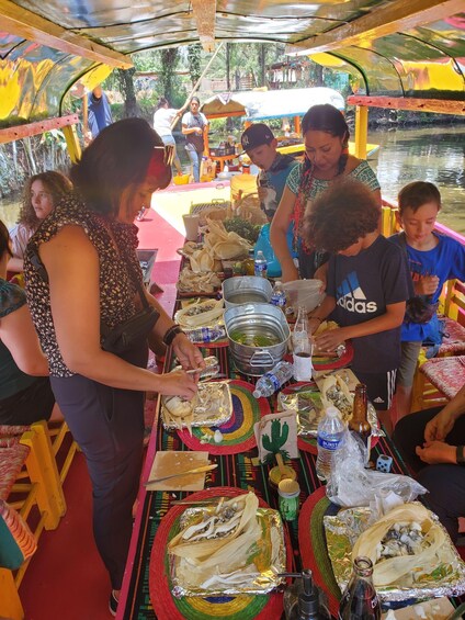 People preparing food on a boat with a river in the background. 4