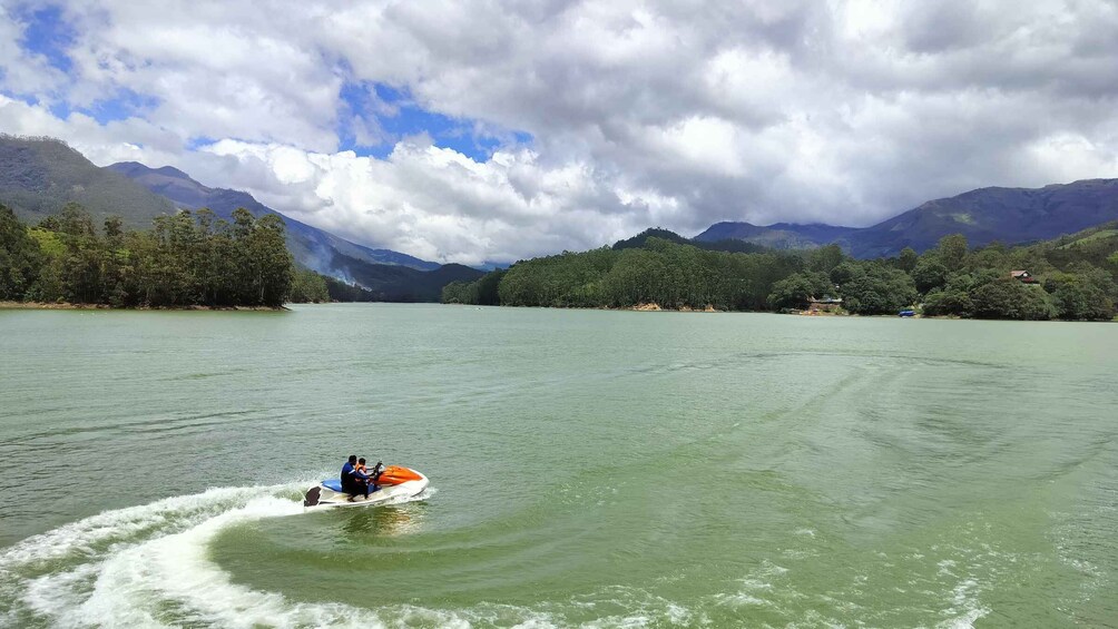 A person jet-skiing on a lake with mountains in the background. 5