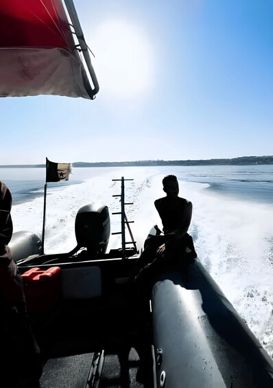 A boat on a frozen lake with a flag and a person sitting at the front. 2