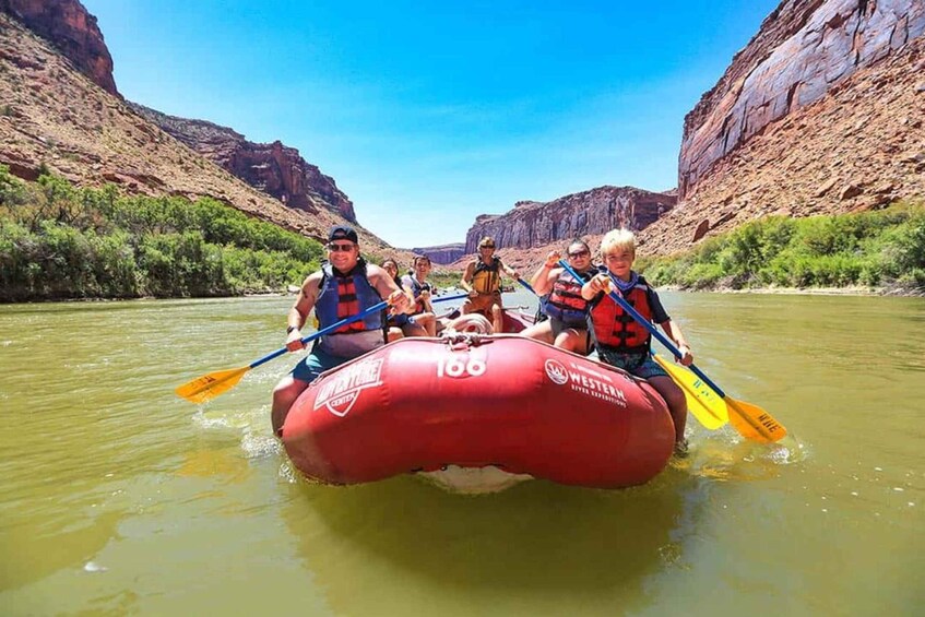 A group of people rafting on a river surrounded by canyon cliffs. 3