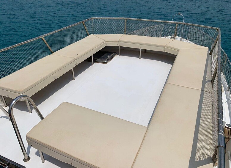 A boat deck with a covered seating area and a central drain. 3