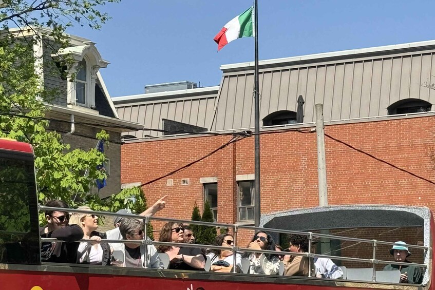 A crowd on a red bus with a flag in the background. 2