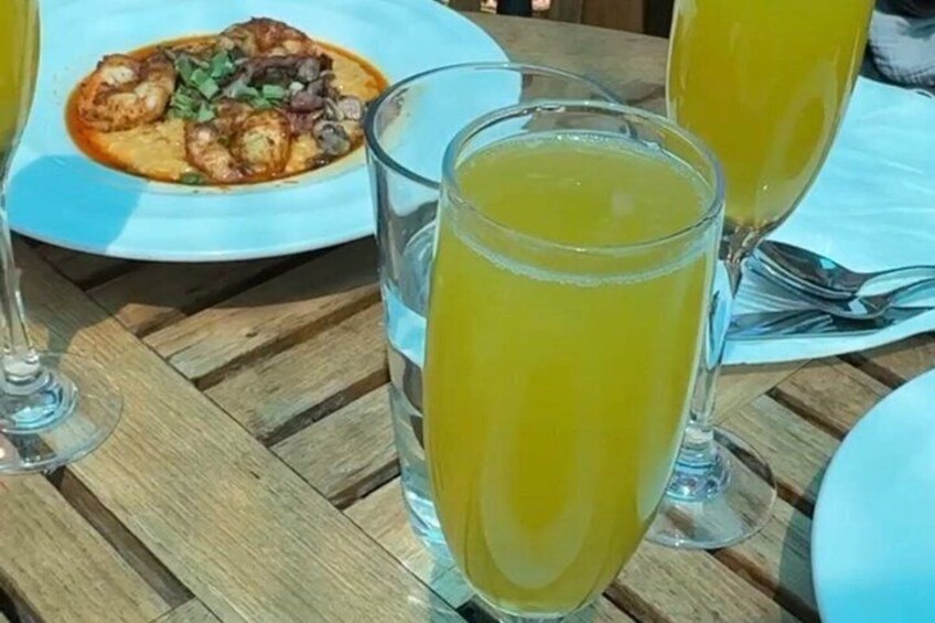 A wooden table with a plate of food and two glasses of orange juice. 4