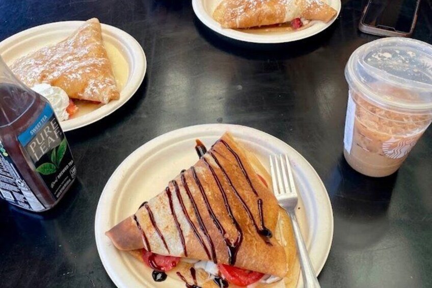 A table with food items including a plate with a pastry drizzled with chocolate, a bottle of sweet tea, and a cup of iced coffee. 5