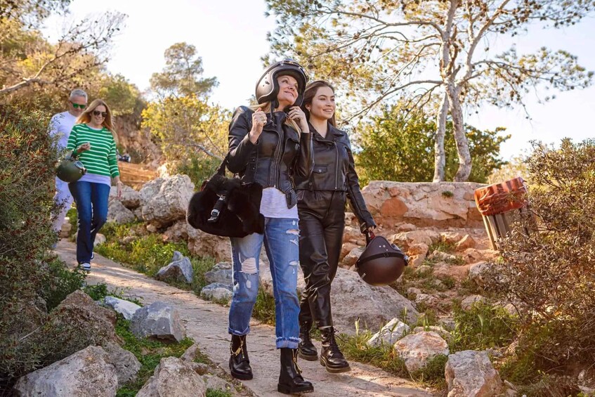 A group of people walking on a rocky path surrounded by trees. 4