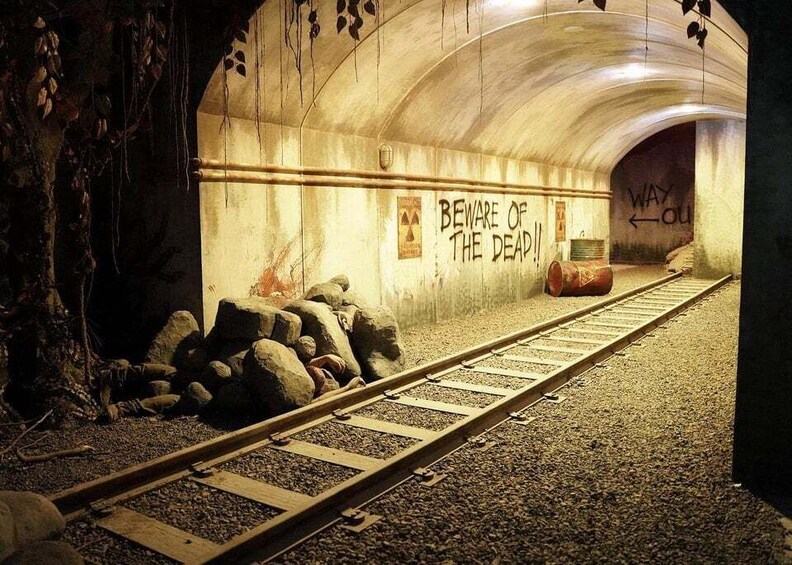 A railway tunnel with graffiti, including 'BEWARE OF THE DEEP!!' and 'WAY OUT'. 3