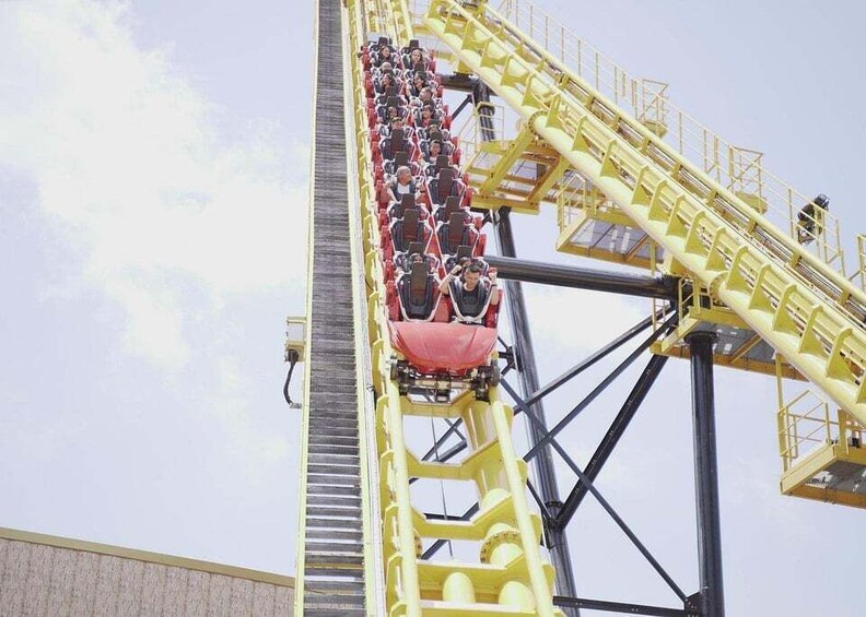 A roller coaster with passengers in red cars. 5