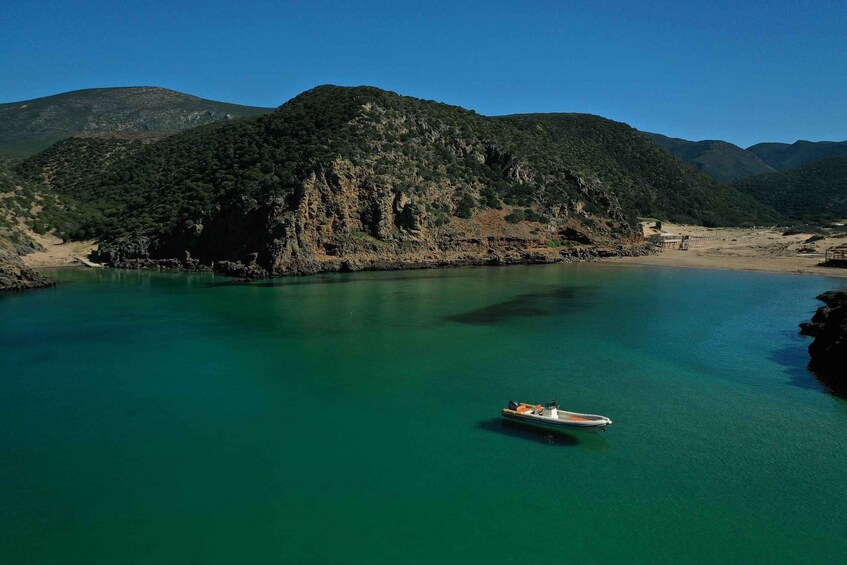 A boat on a turquoise lake surrounded by green hills. 5