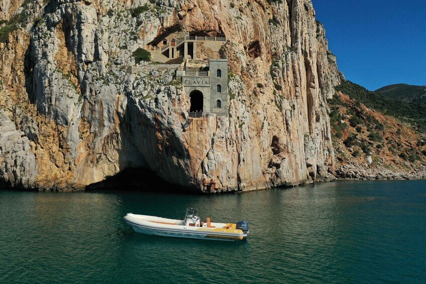 A boat in a cove with a rocky cliff and a building labeled 'Port of Flavia' above. 1