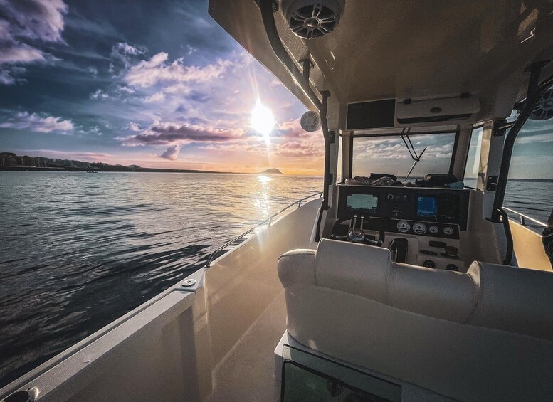 A boat's interior with a view of the sunset over water. 1