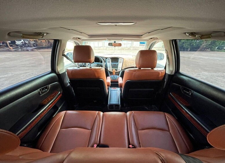 The interior of a car with brown leather seats and a central console. 3