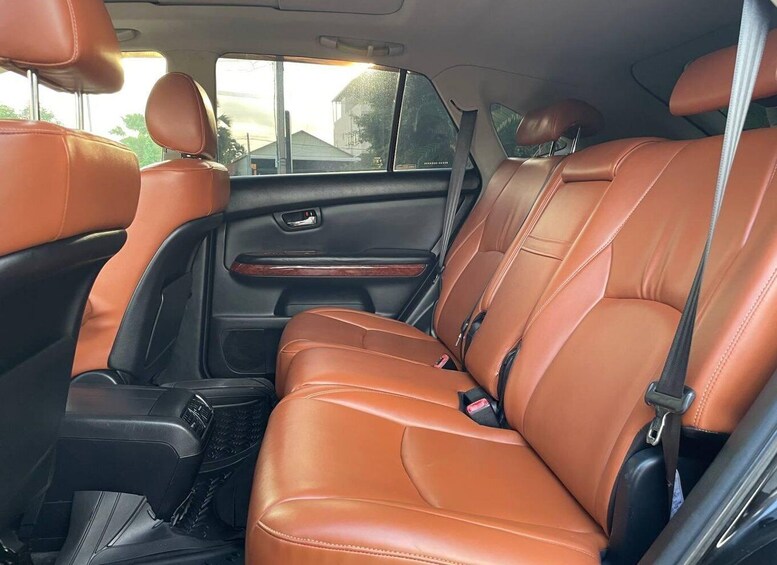 A car interior with brown leather seats, a center console, and a rearview mirror. 5