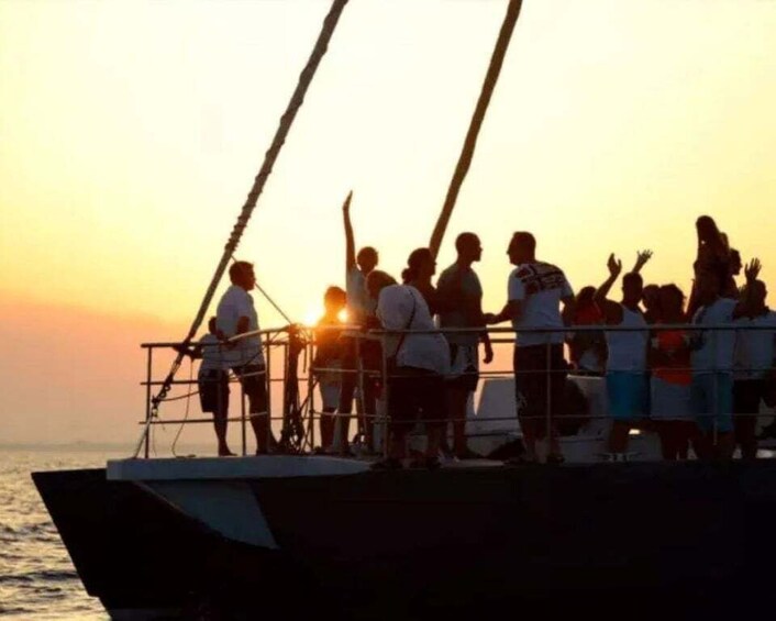 A group of people on a boat during sunset. 1