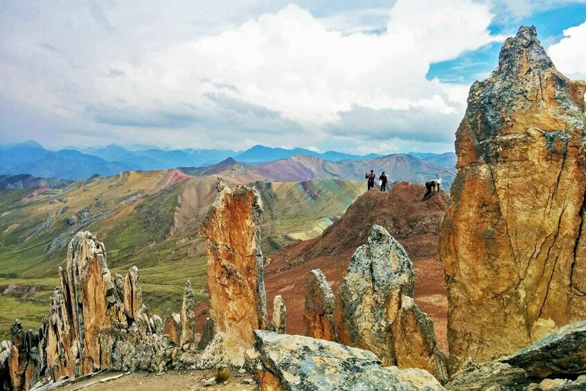 A mountainous landscape with prominent rock formations and hikers on a ridge. 3