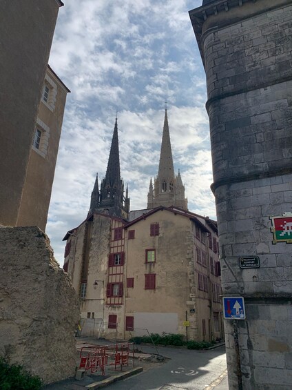 A historic building with a pointed spire, a stone tower, and a sign indicating 'Boulevard Rempart Lachepinlet.' 4