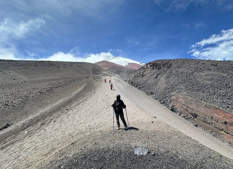 A person hiking on a rocky trail with a mountain in the background. 5