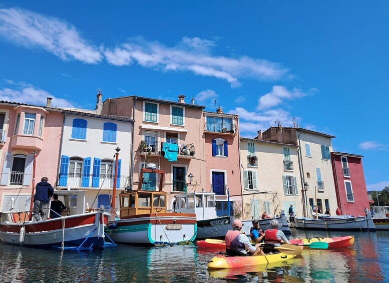 A row of colorful boats docked at a pier with buildings in the background. 5