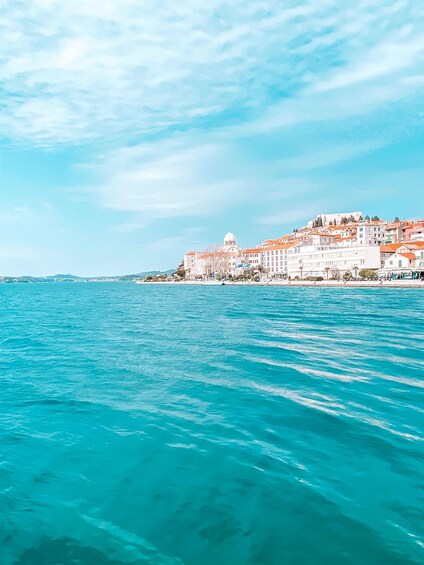 A coastal town with buildings and a clear blue sea. 4
