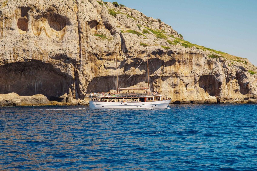 A boat sailing near a rocky coastline with cliffs. 5