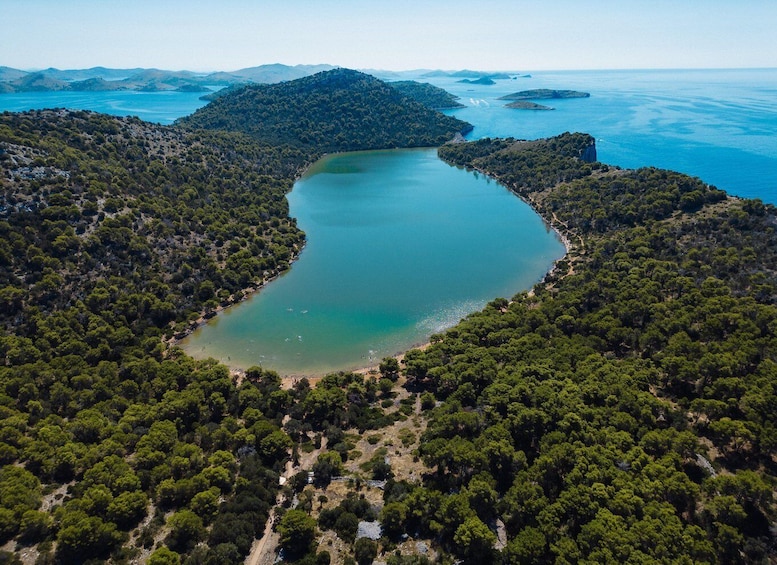 An aerial view of a lake surrounded by dense forest and hills. 5