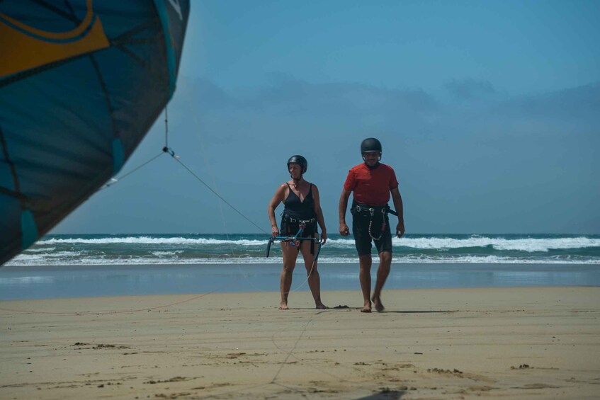 Two people on a beach with a kite in the foreground. 3
