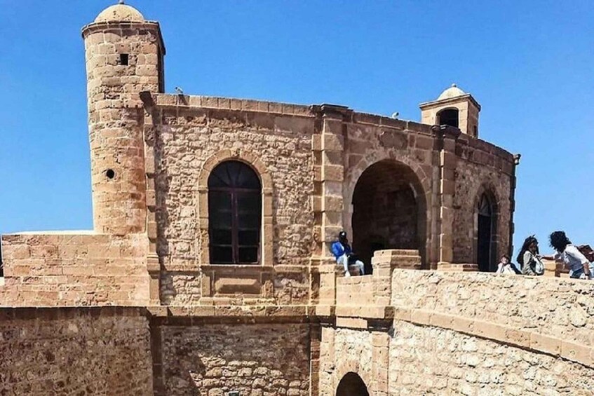 An ancient stone structure with arched windows and a tower. 4