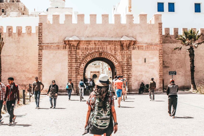A historic gate with people walking through it. 5