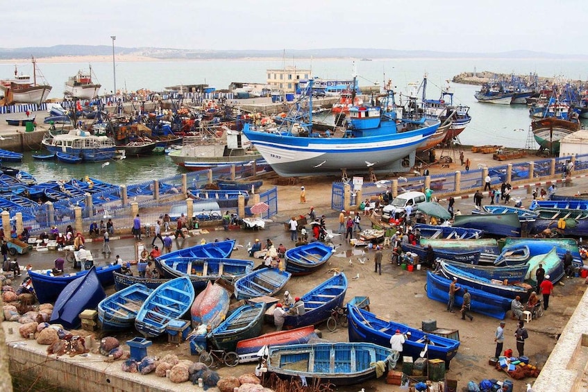 A busy harbor with numerous small boats docked and people engaged in various activities. 5